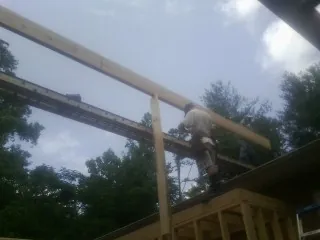 Carpenter setting a ridge beam over a new addition frame — Ice Dam Removal by Roofing Brothers in Eaton